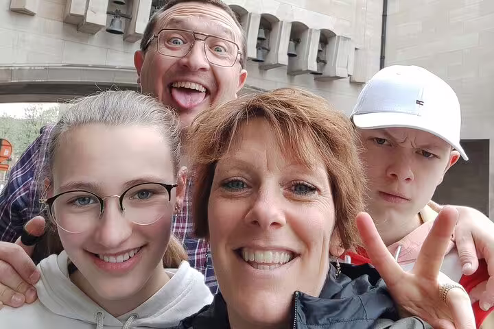Family of four taking a fun selfie together during a walking tour of a historic town