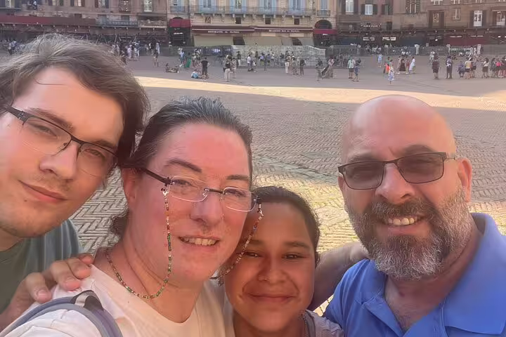Family taking a selfie at Piazza del Campo in medieval Siena, Italy