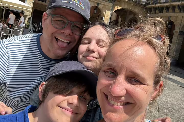 Happy family taking a selfie in San Sebastian Old Town plaza during a walking tour