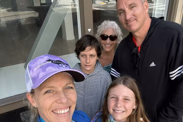 Family group selfie of five people smiling outdoors during Seattle walking tour