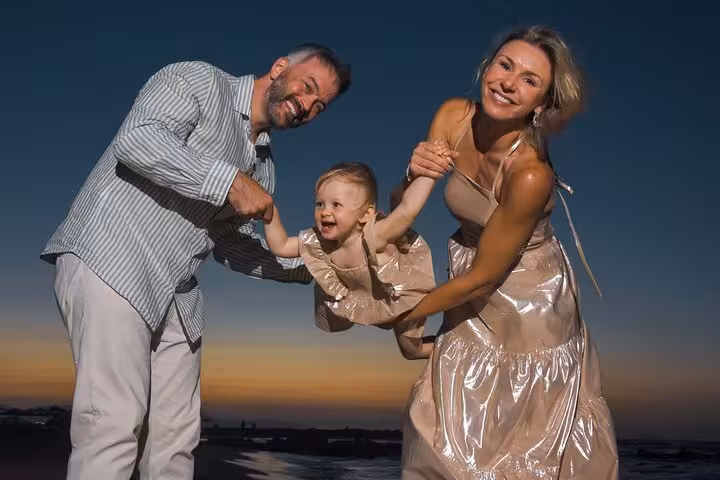 Happy family enjoying a sunset photoshoot on a Heraklion beach, capturing joyful moments by the sea.