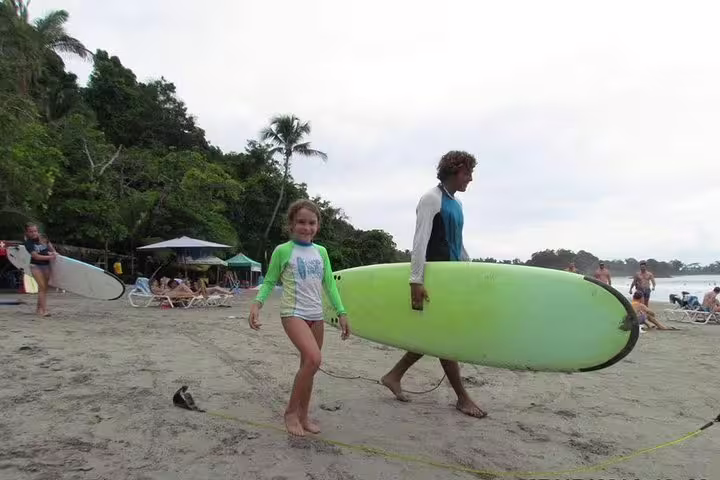 Family enjoying a beach day in Manuel Antonio, Costa Rica, with surfboards, perfect for a SUP tour.