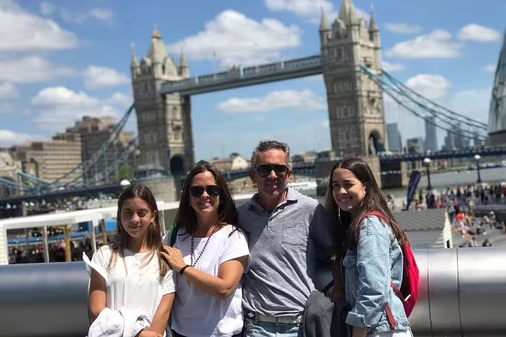 Family enjoying a sunny day near Tower Bridge during a private skip-the-line Tower of London tour with lunch experience.