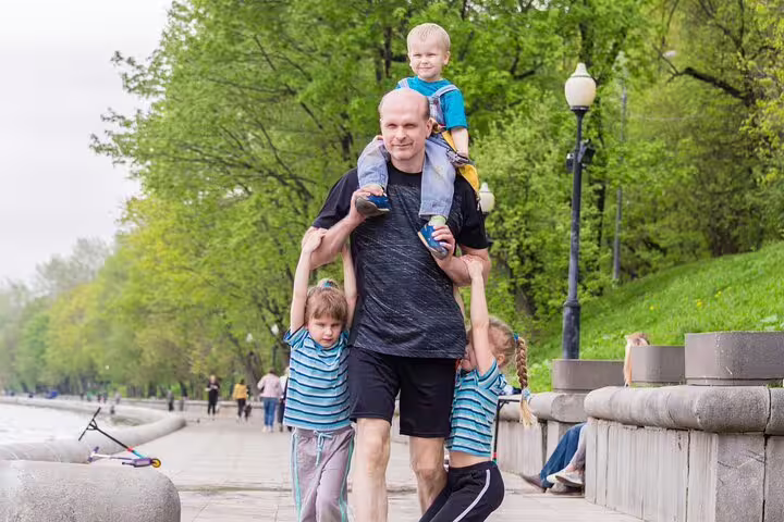 Family walking in a green city park, enjoying a fun self-guided Vienna e-scavenger hunt adventure