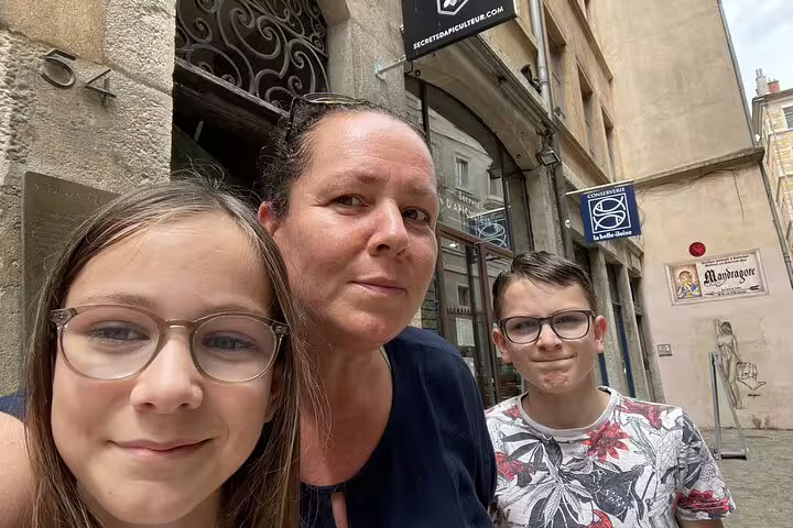 Family selfie in Lyon Old Town street with historic buildings and shops in background