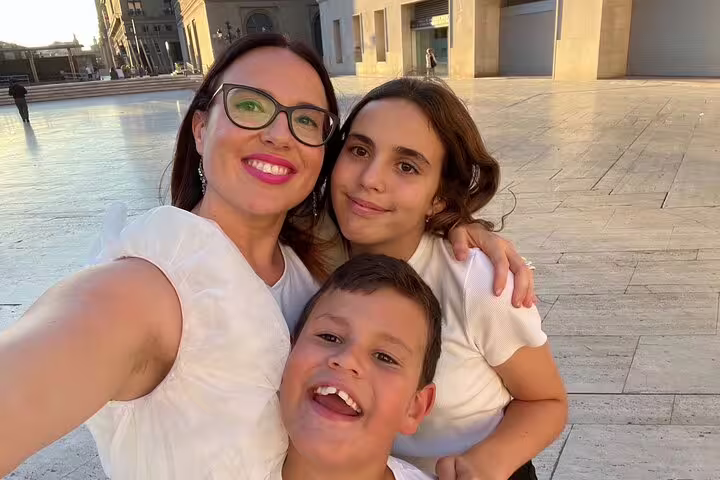 Family selfie in a sunny Zaragoza plaza during a self-guided scavenger hunt and sightseeing walking tour