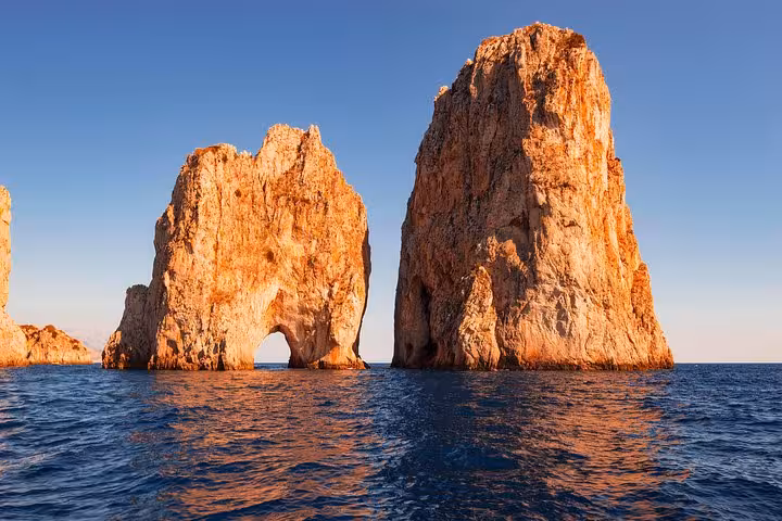Majestic Faraglioni rock formations in Capri seen during a small group boat tour from Sorrento.