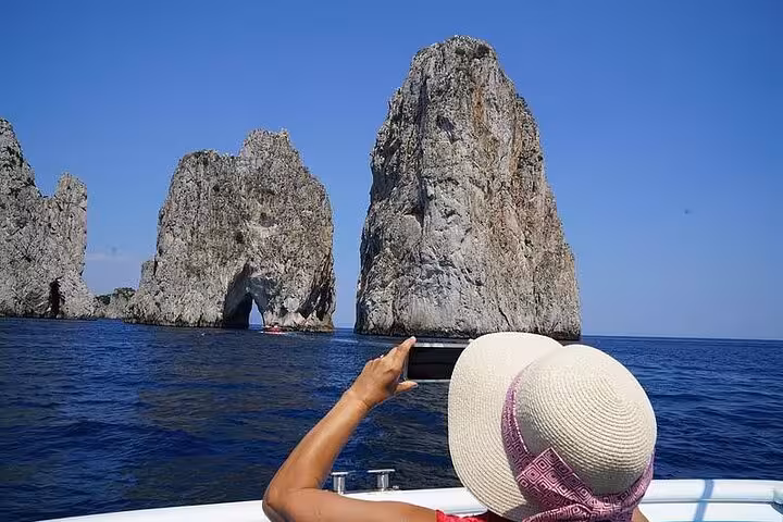 Capture breathtaking views of the Faraglioni rocks on a scenic boat tour from Naples to Capri and Sorrento coast.