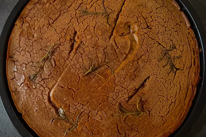 Golden farinata with rosemary on a traditional Chiavari food tour, highlighting Ligurian culinary delights.