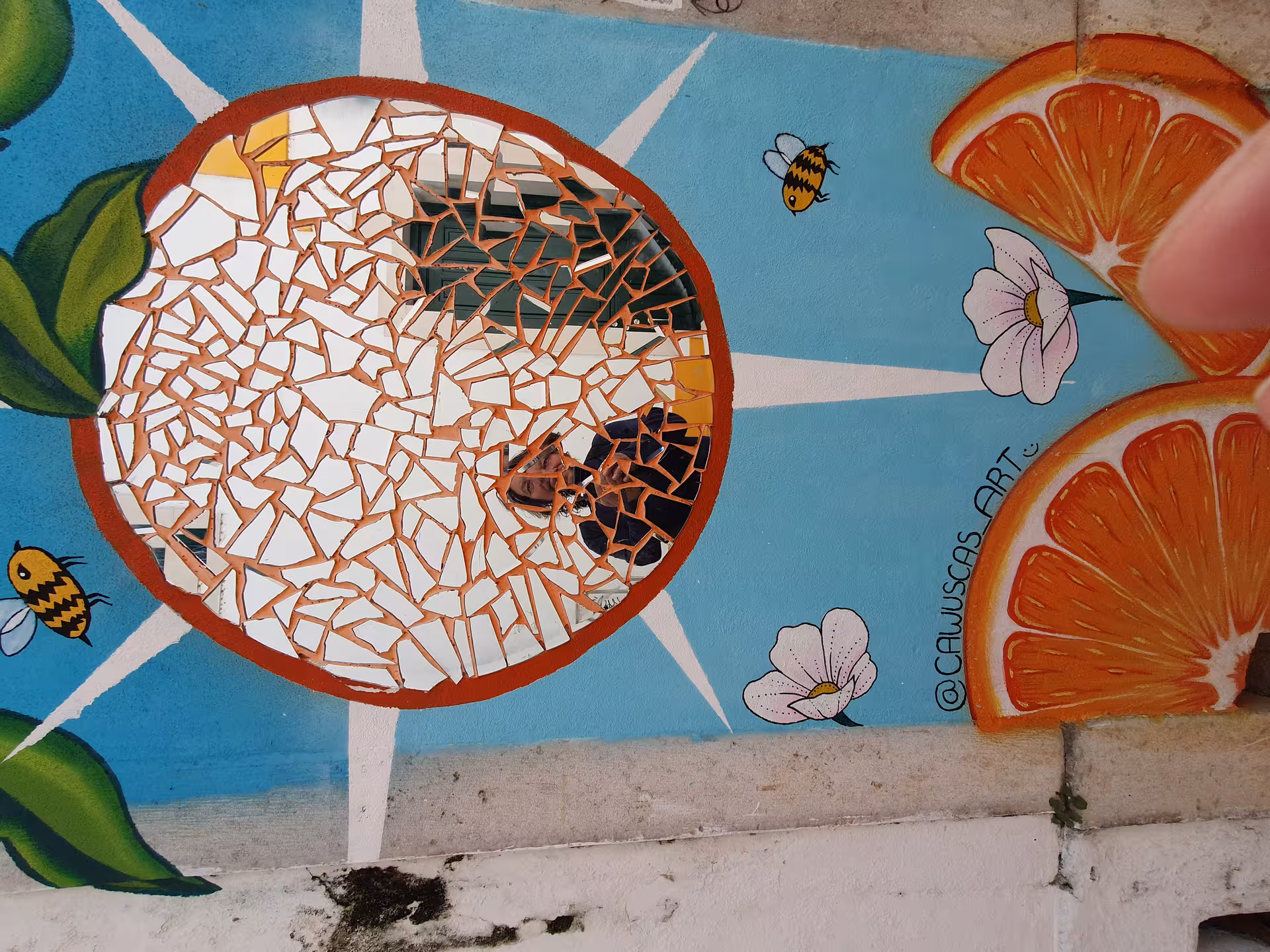Vibrant mosaic street art with orange slices and bees in Faro, perfect for exploring on an Algarve walking tour.