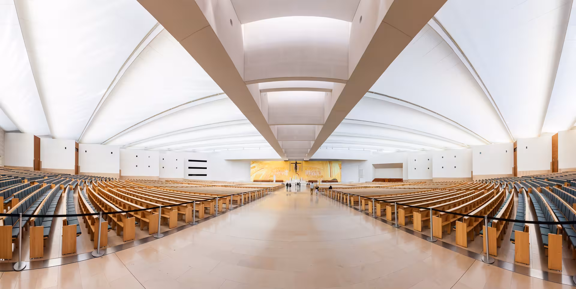 Panoramic view of the spacious interior of the modern Fátima Basilica, highlighting its architectural elegance.