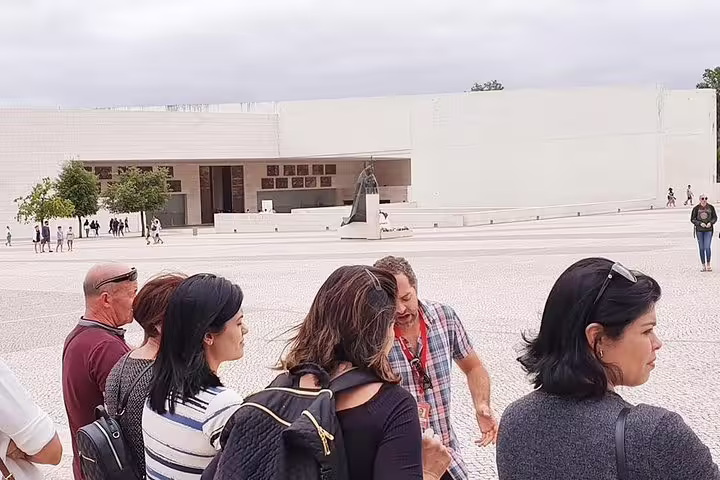 Tour group exploring the Sanctuary of Fátima with a guide during the Fátima & Coimbra full-day private tour from Porto.