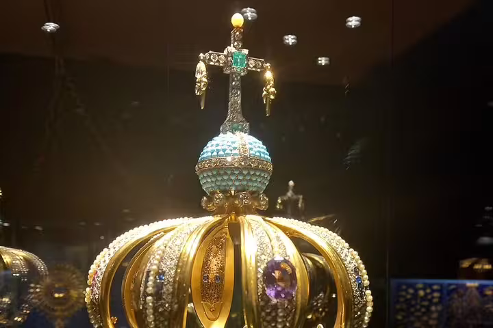 Close-up of an ornate crown with gemstones, featured in a Fatima exhibit on the Private Fatima Sintra Tour.