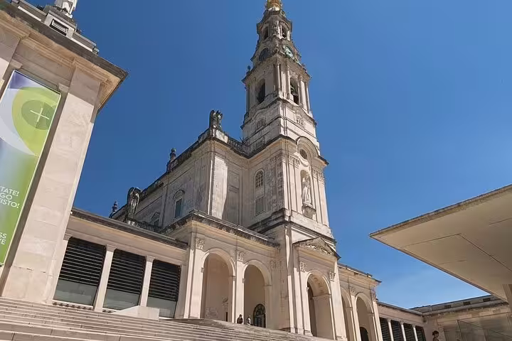 Stunning view of the Sanctuary of Fátima's iconic basilica on a sunny day, featured in our Fátima, Nazaré, and Óbidos full-day tour.