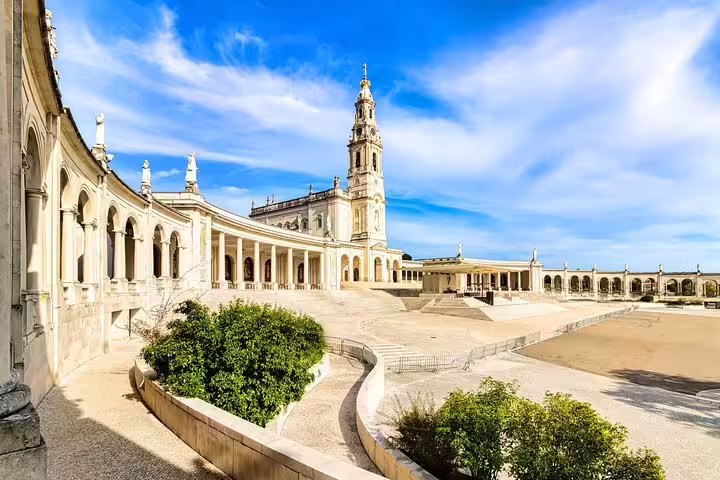 Stunning view of the Sanctuary of Fátima's architecture under a blue sky, a highlight of the Lisbon day tour to Fátima, Nazaré, and Óbidos.