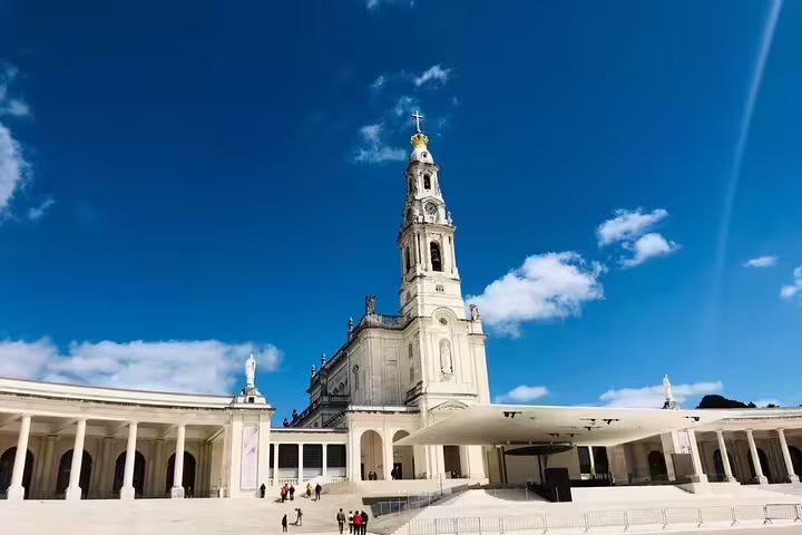 Stunning view of the Sanctuary of Our Lady of Fatima against a clear blue sky, featured in a private day tour to Fatima, Batalha, Nazaré, and Obidos.