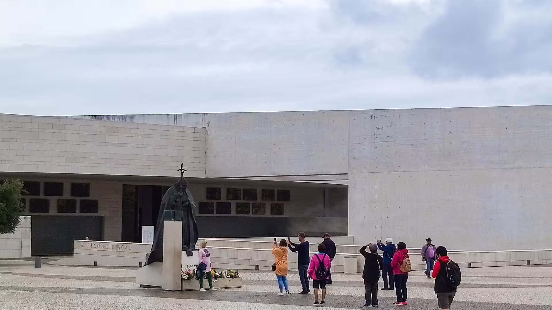 Visitors capturing photos at Fátima Sanctuary near the statue of Pope John Paul II during a private tour of the Little Shepherds Houses.