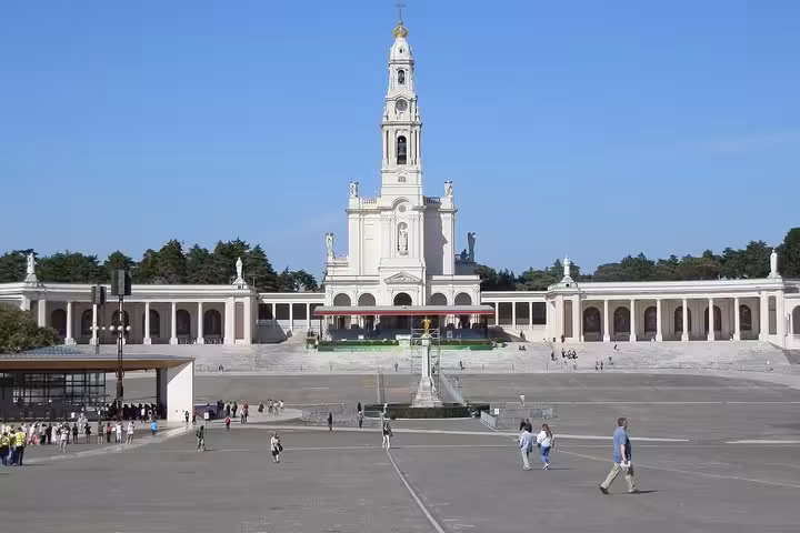 The Sanctuary of Fátima under a clear blue sky, a prominent stop on the private tour to Fátima, Batalha, Nazaré, and Óbidos.