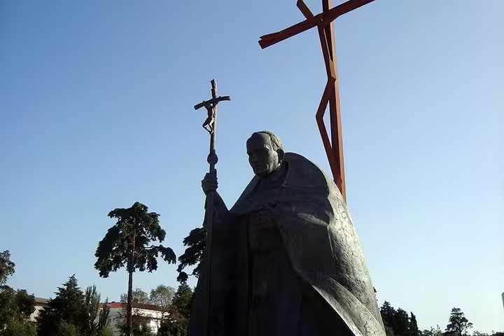 Statue of a religious figure holding a cross at the Sanctuary of Fátima, highlighting the spiritual ambiance of the tour.