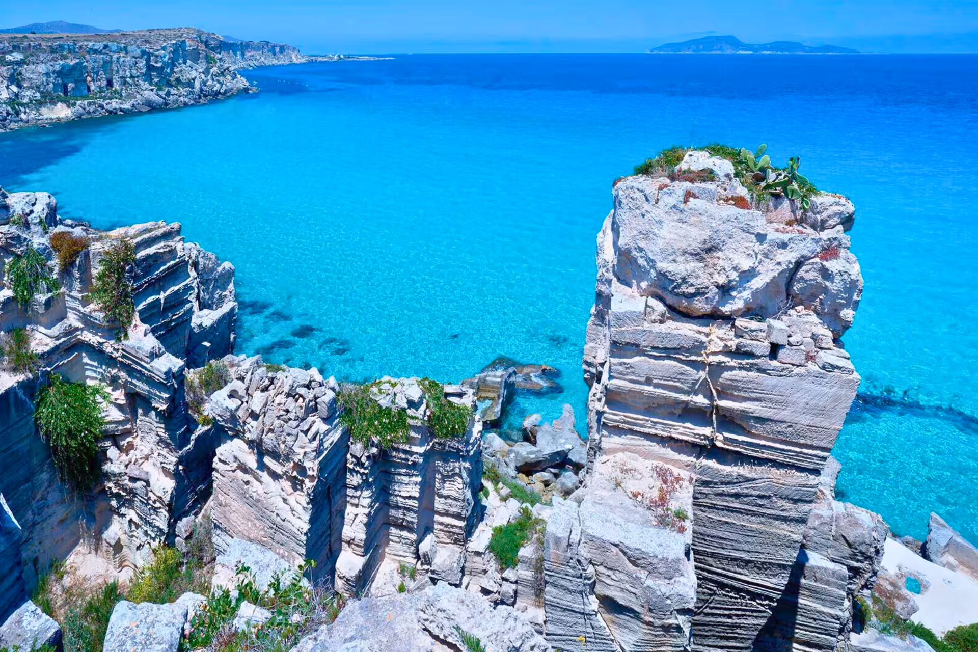 Favignana sea cliffs and crystal-clear turquoise water on Egadi Islands private dinghy tour from Trapani