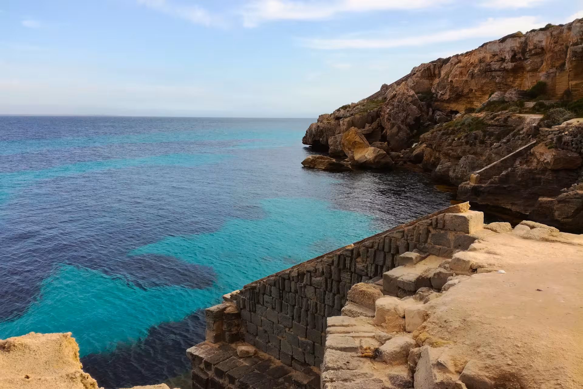 Stone steps to a cliffside swim spot in Favignana, Egadi Islands dinghy excursion from Trapani with lunch