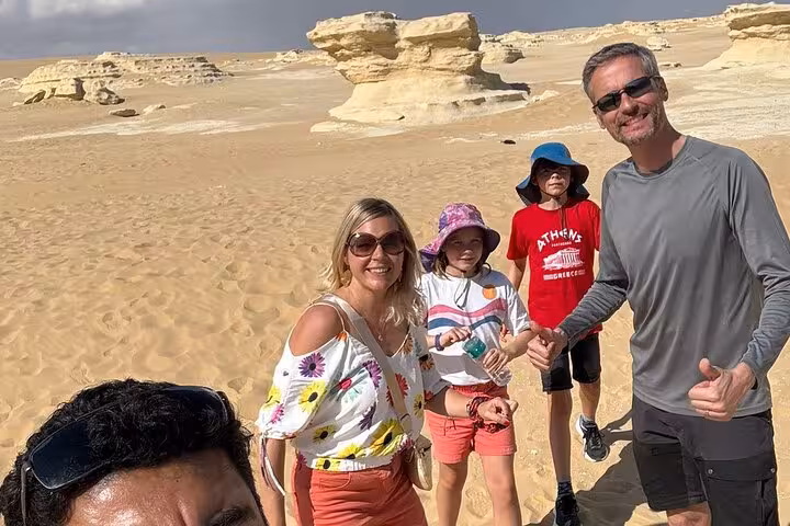 Tourists at White Desert-style rock formations and dunes in Fayoum Oasis during a private full-day trip from Cairo