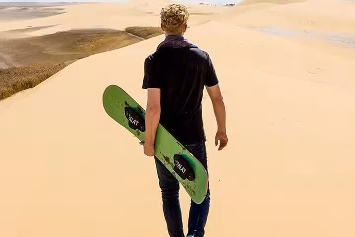 Sandboarding adventure in Fayoum Oasis dunes near Magic Lake, thrilling Cairo desert tour with boardsports