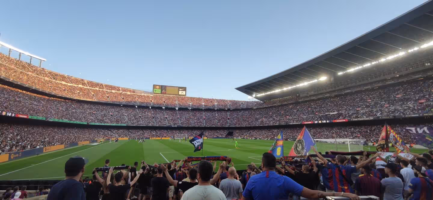 Crowd view inside FC Barcelona stadium during live match, fans waving flags on local game experience tour
