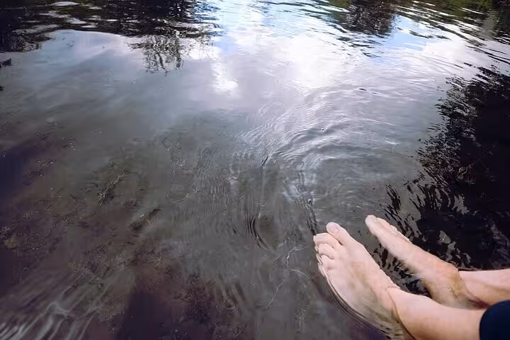 Bare feet soaking in the warm shallow waters of Reykjadalur hot springs river in Iceland