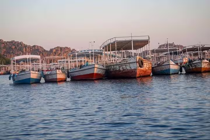 Moored felucca and riverboats on the Nile in Luxor at sunset, ideal for a relaxing sail tour