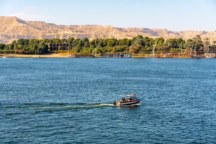 Nile River in Luxor with boats and West Bank hills, scenic backdrop for a felucca sailing tour