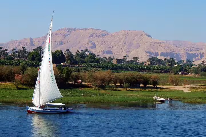 Traditional felucca sailing on the Nile with West Bank hills, classic view on 4 nights 5 days Luxor Nile cruise