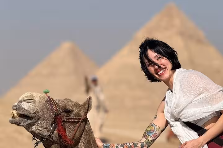 Traveler with camel before Giza pyramids on Cairo tour led by an expert female Egyptologist guide