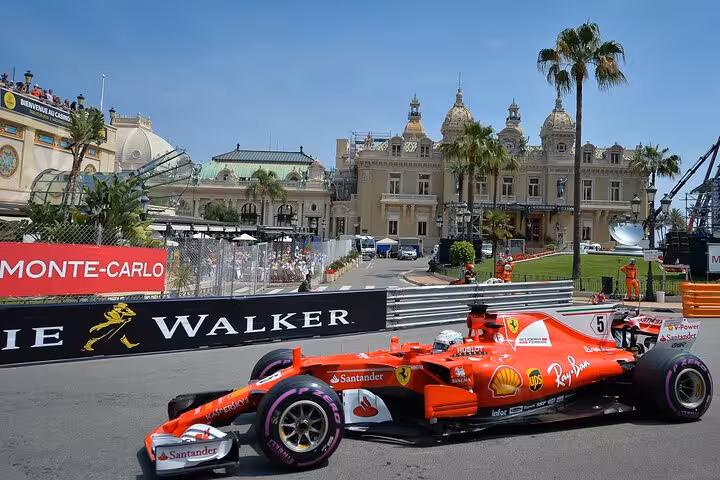 Ferrari Formula 1 car racing past Monte Carlo Casino during Monaco Grand Prix