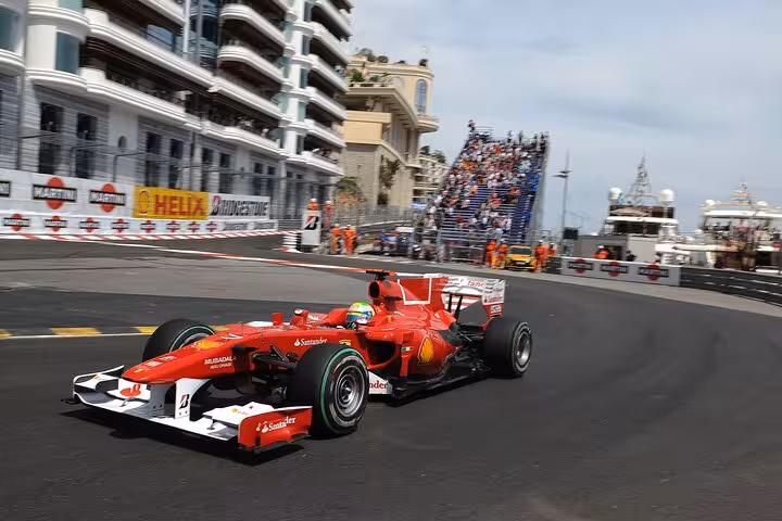 Ferrari Formula 1 car racing on Monaco Grand Prix street circuit with spectators
