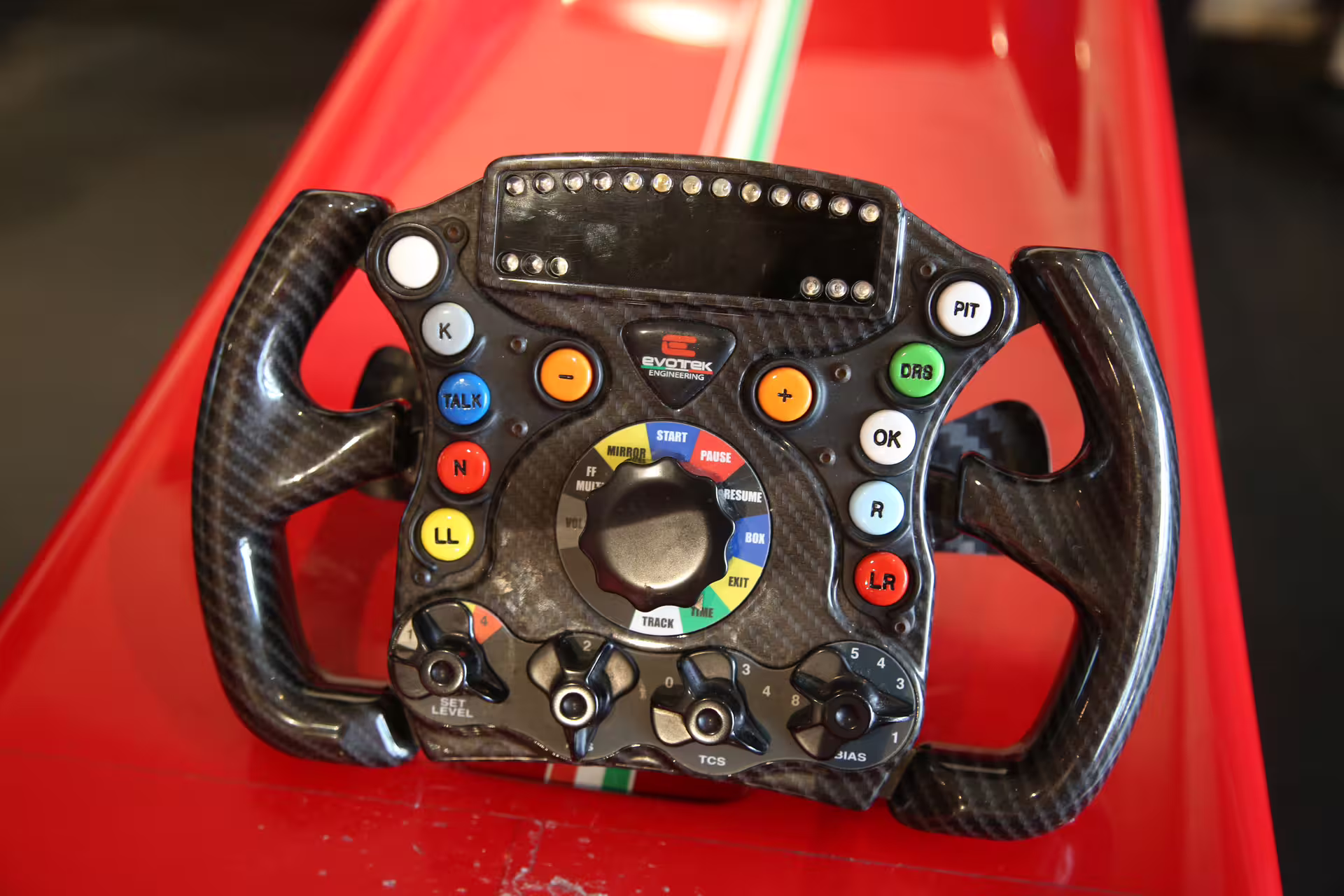 Close-up of a professional F1 simulator steering wheel at Maranello's Ferrari Museum, showcasing intricate controls.