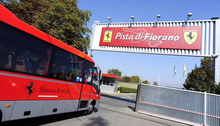 Red Ferrari Museum shuttle at Pista di Fiorano entrance, Maranello panoramic track tour with ticket