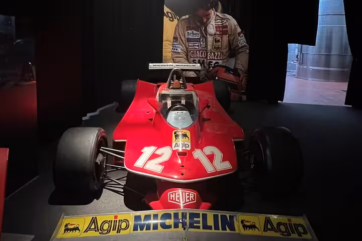 Classic red Ferrari race car displayed in a museum, part of small group tour with lunch featuring Lamborghini and culinary delights.