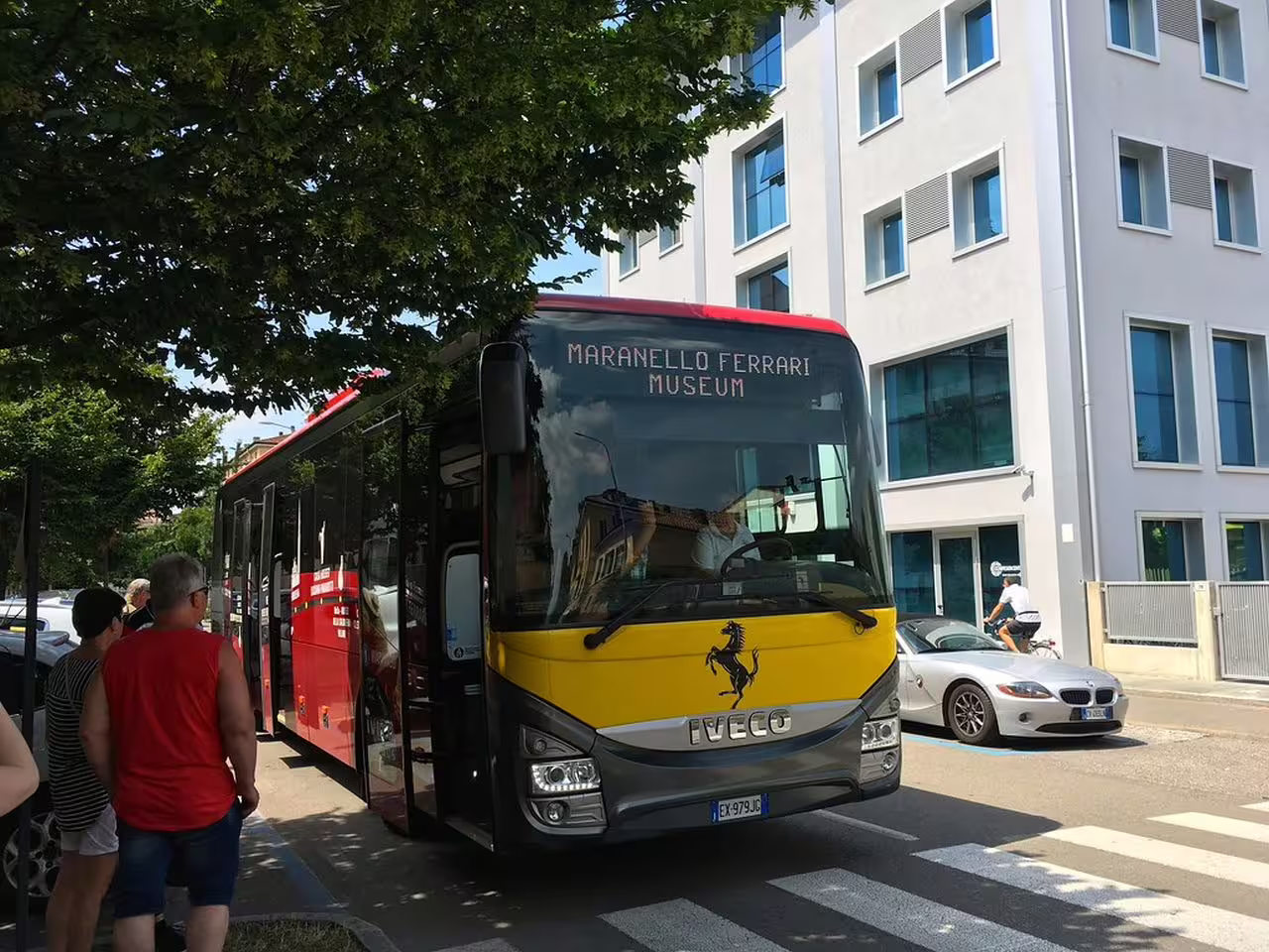 Tourists board the Maranello Ferrari Museum transfer bus, offering convenient transit between Ferrari attractions.