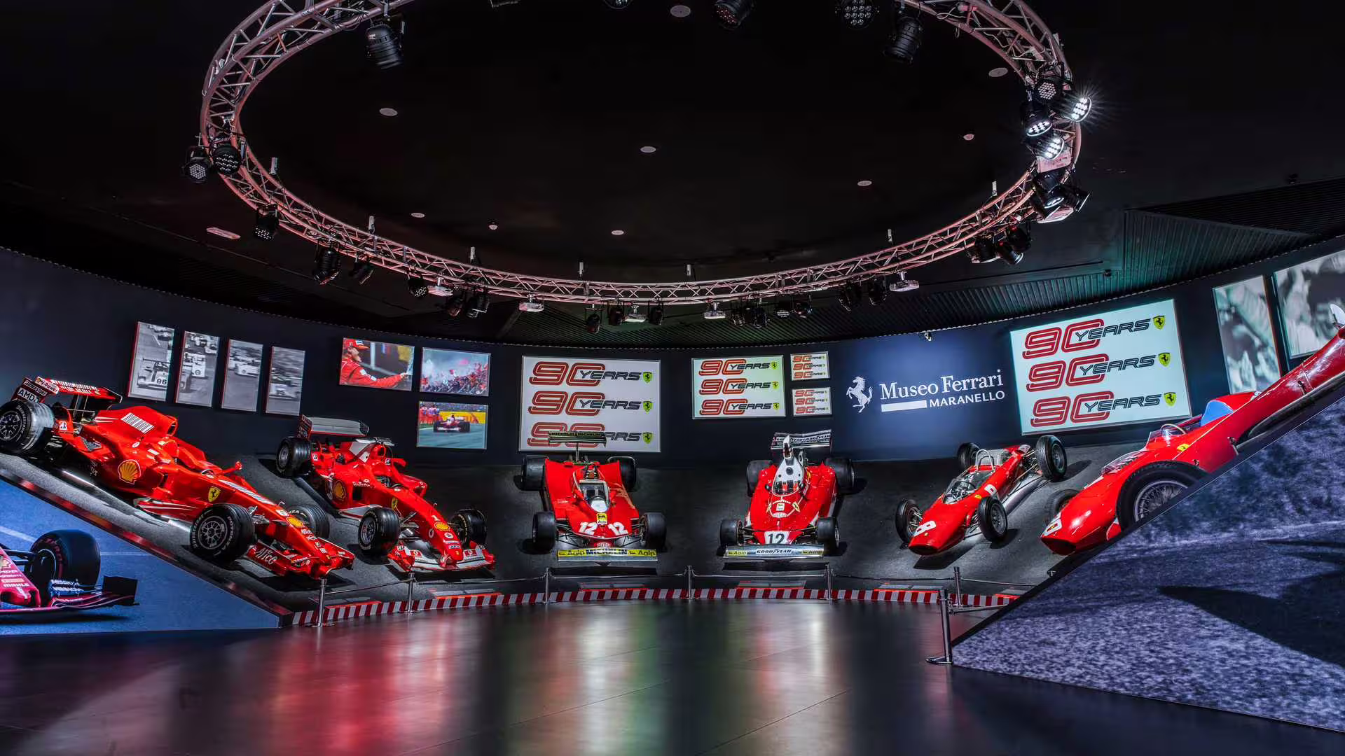 Museo Ferrari Maranello gallery showcasing historic Ferrari F1 cars under lights, included museum entrance ticket