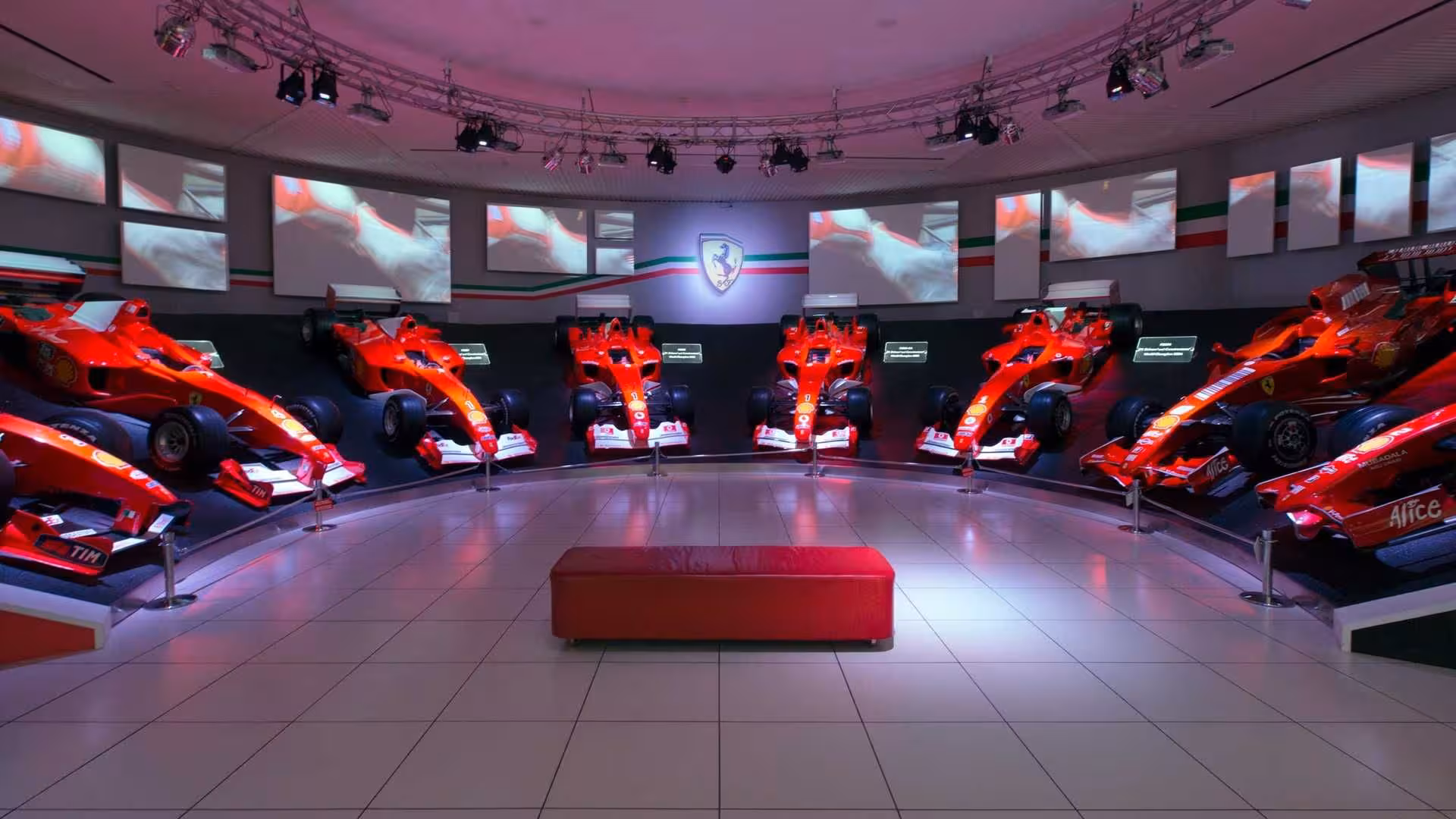 Ferrari Museum Maranello F1 gallery with multiple red race cars, part of Maranello Modena museums plus Mirabilandia entry