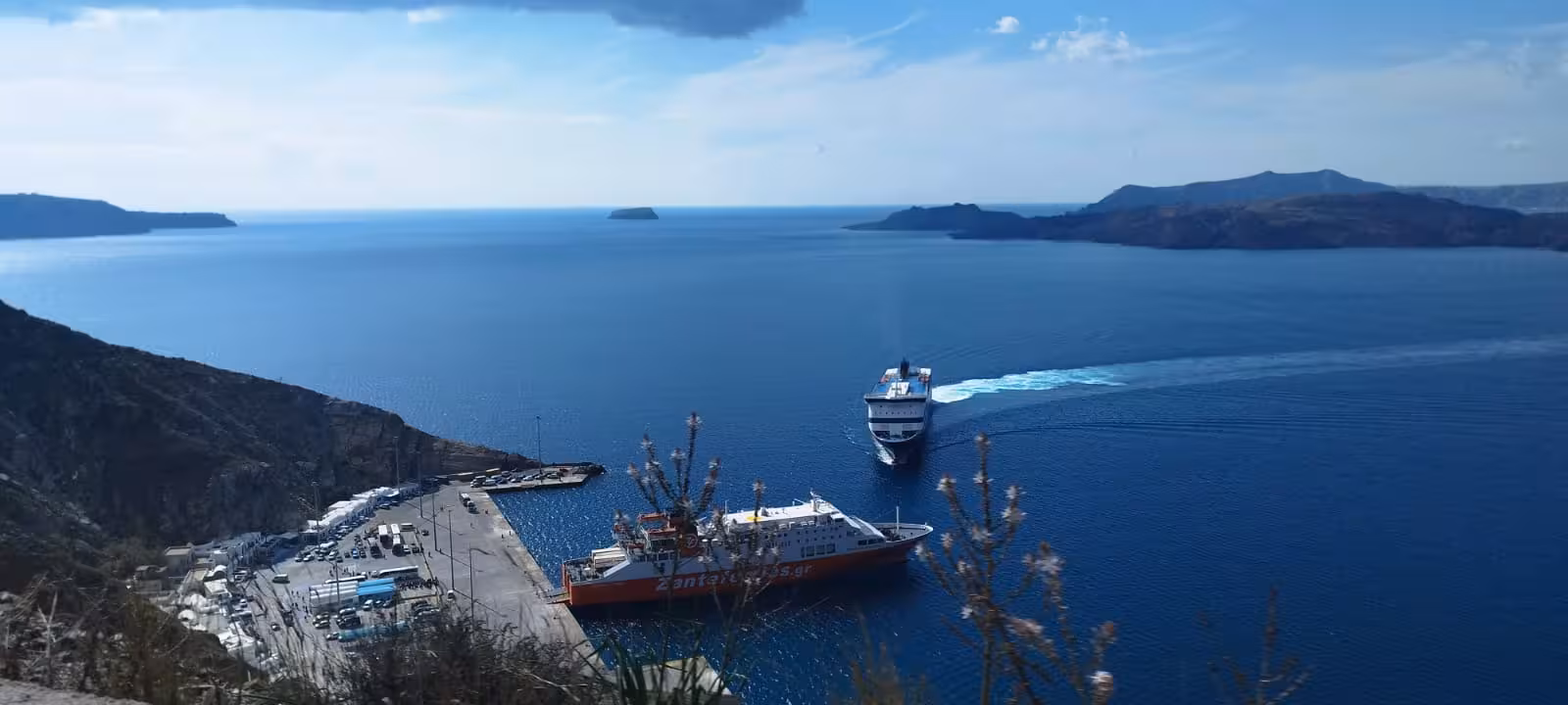 Ferry arriving in Santorini caldera above port view, shared transfer service for cruise and ferry arrivals