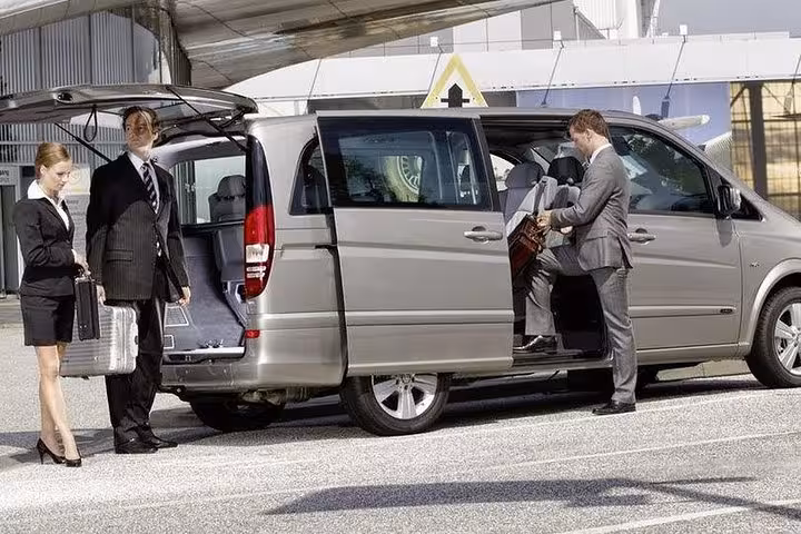 Business professionals preparing for a transfer from Fes to Merzouga in a sleek van.