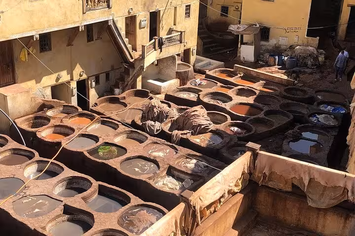 Traditional Fes tannery with colorful dyeing pits, showcasing authentic Moroccan craftsmanship on the desert tour to Fes.