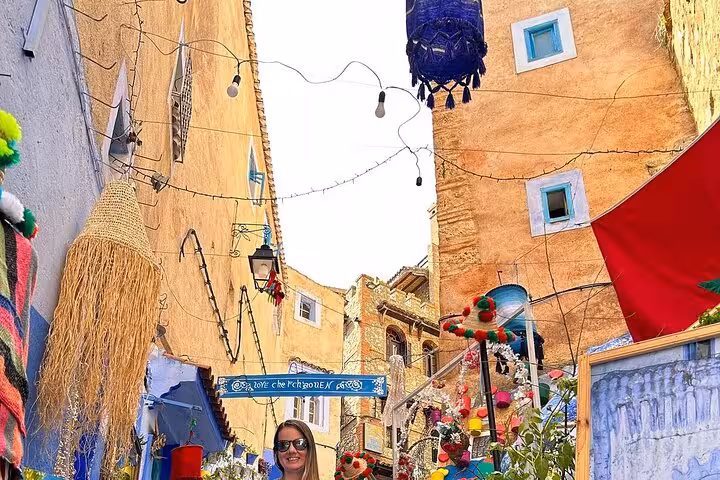 Vibrant street scene in Chefchaouen showcasing colorful decor and architecture on a guided tour from Fez.