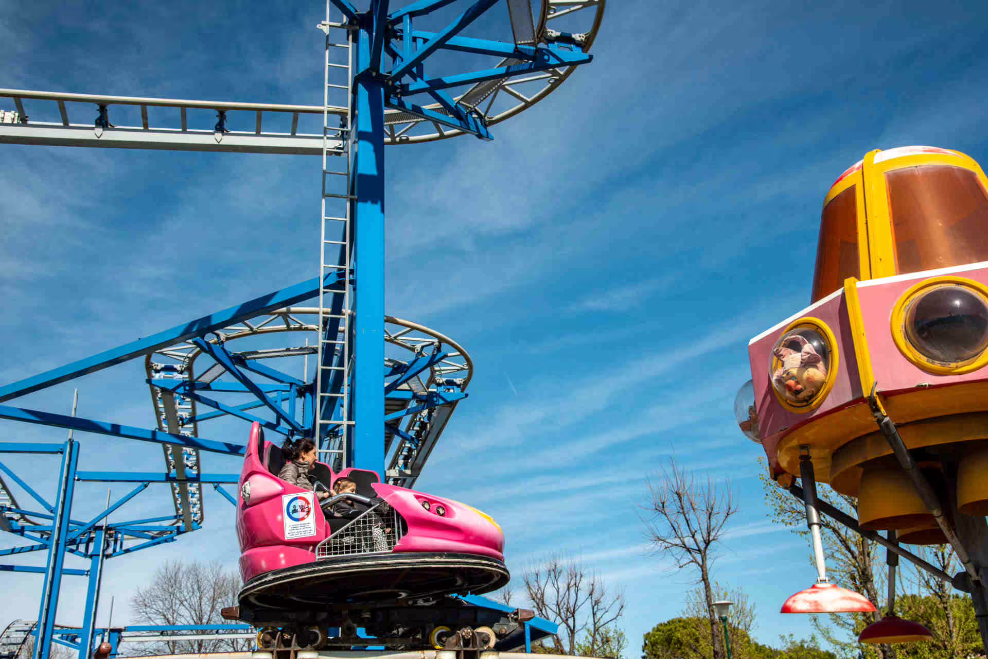 Pink roller coaster car on Fiabilandia ride in Rimini, Italy, family-friendly amusement park entrance ticket