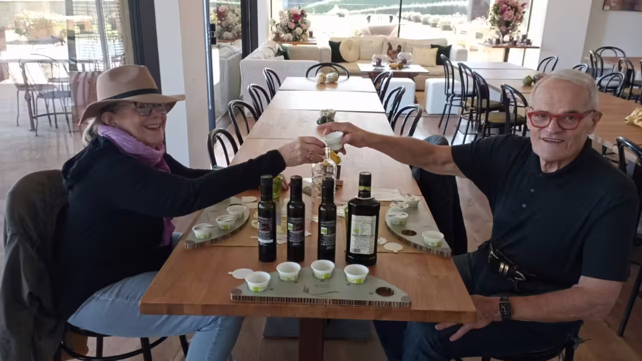 Couple toasts during Fiesole Olio EVO Bronze Experience at Frantoio Buonamici tasting table