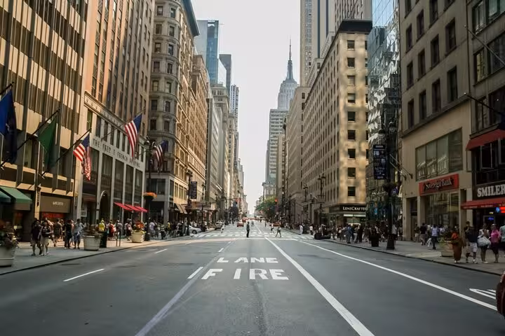 Fifth Avenue Manhattan street view with Empire State Building and historic buildings lining wide urban boulevard