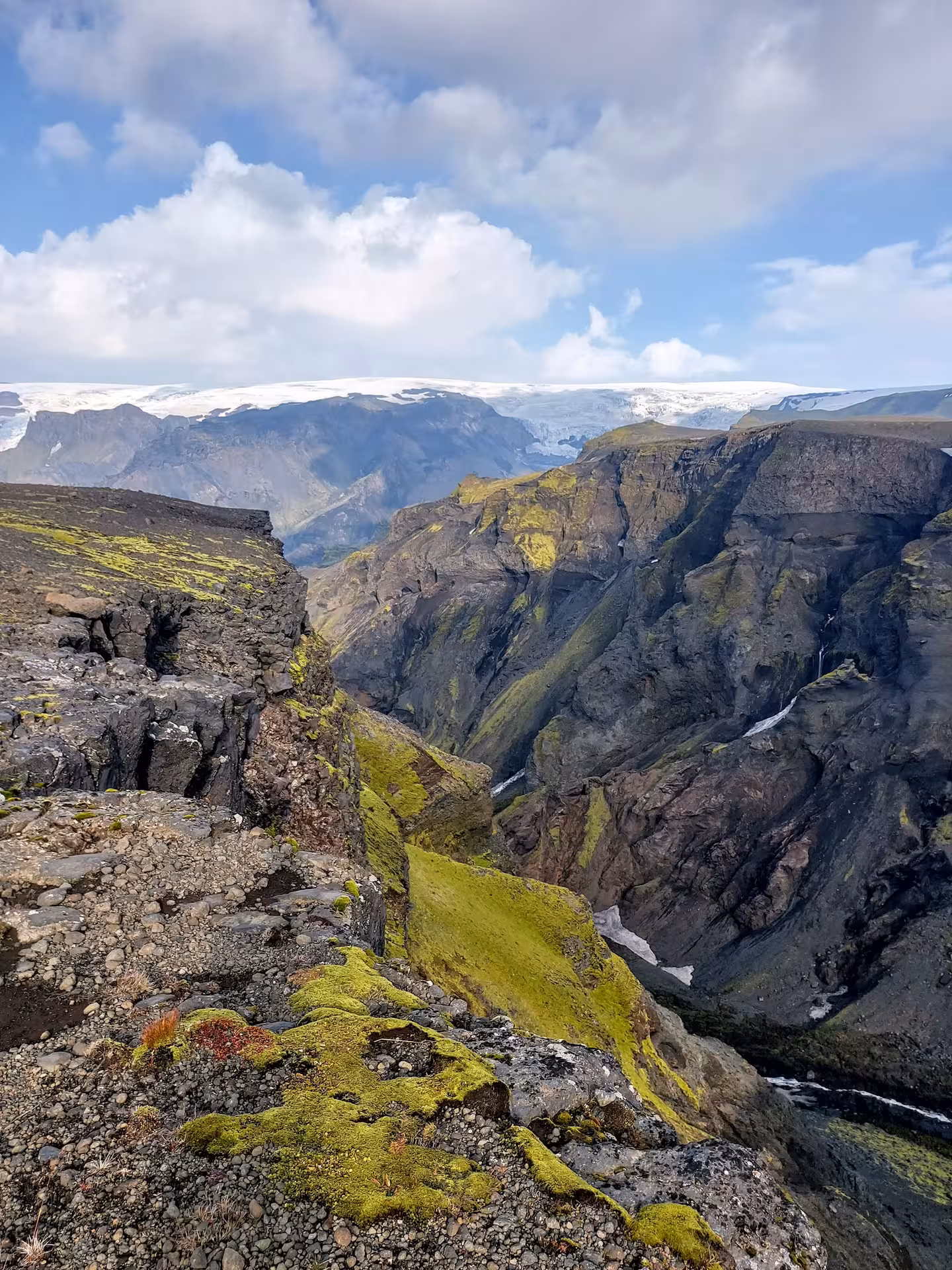 Deep volcanic canyon with moss-covered cliffs and glacier views on Fimmvorduhals hike Iceland