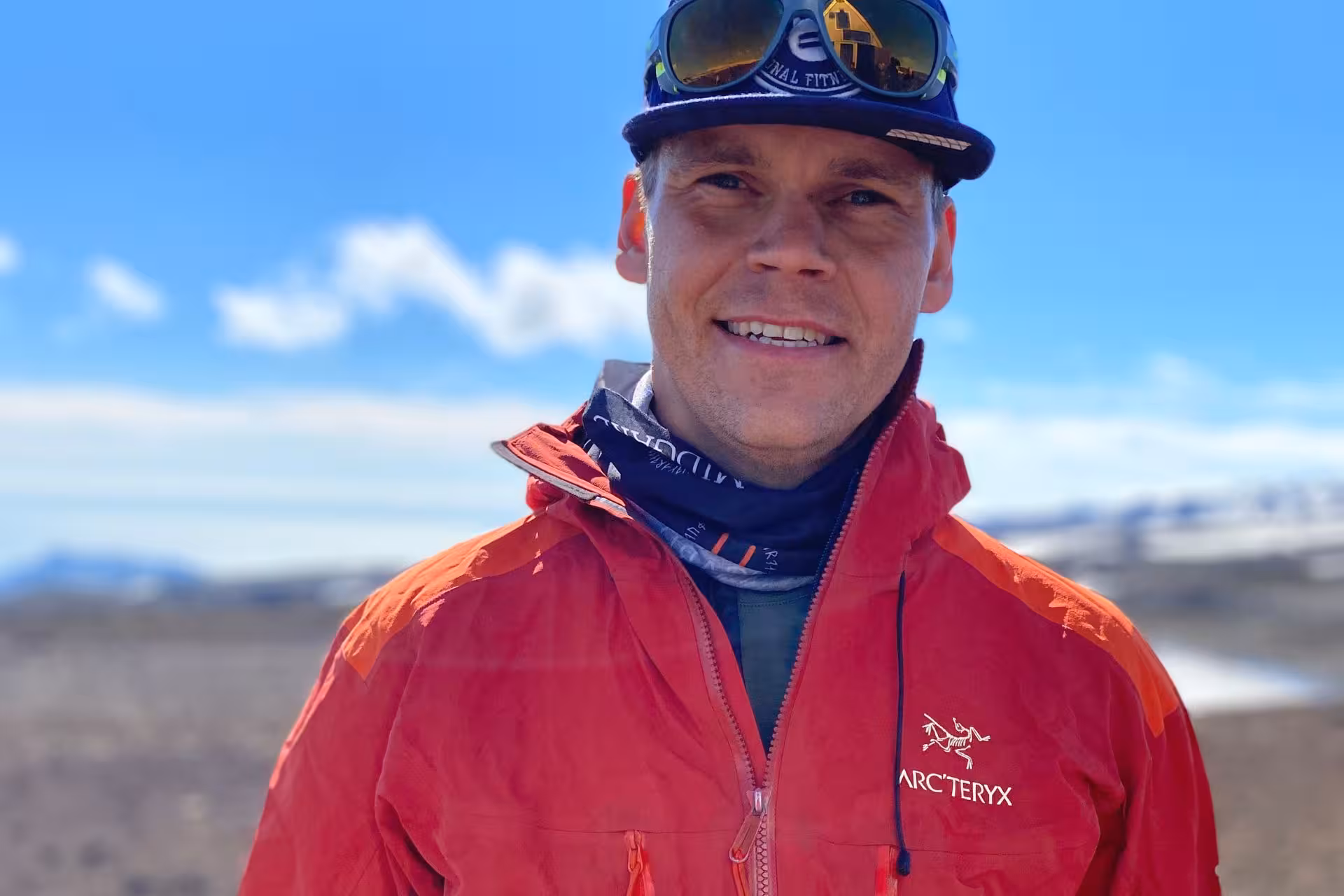 Smiling male guide in red Arc'teryx jacket and cap on Fimmvorduhals hike in Iceland